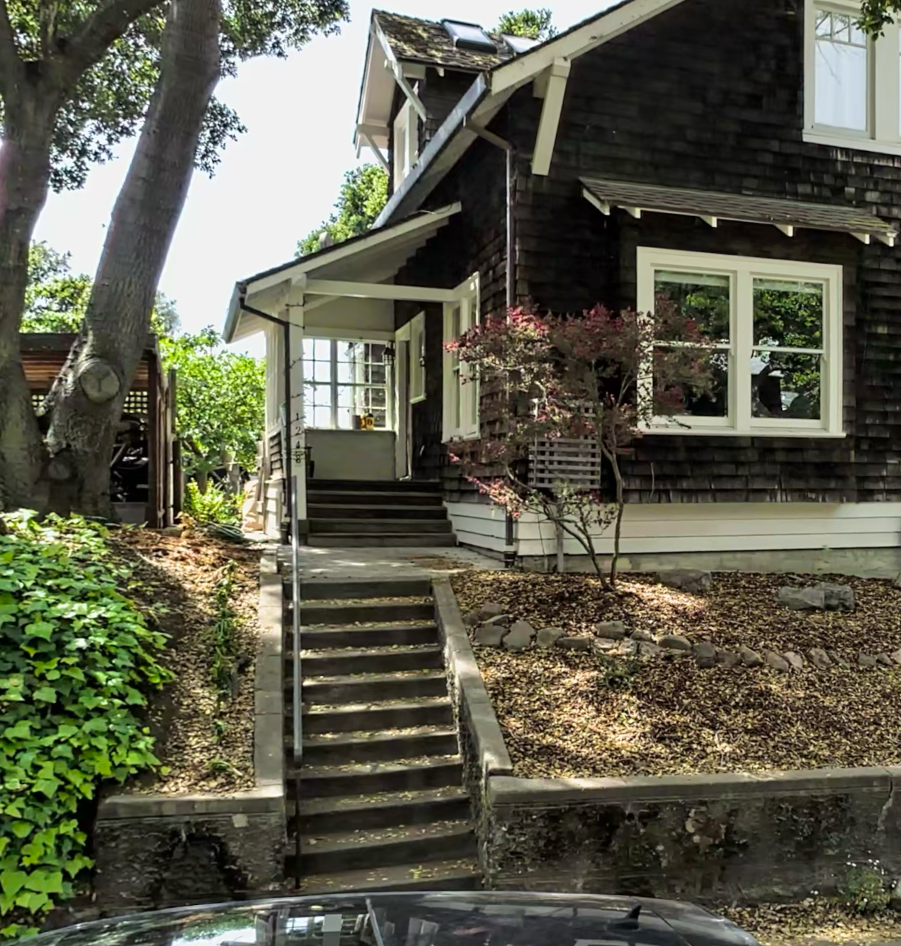 A craftsman-style home with concrete front steps leading up to the porch – no handrail on the upper portion